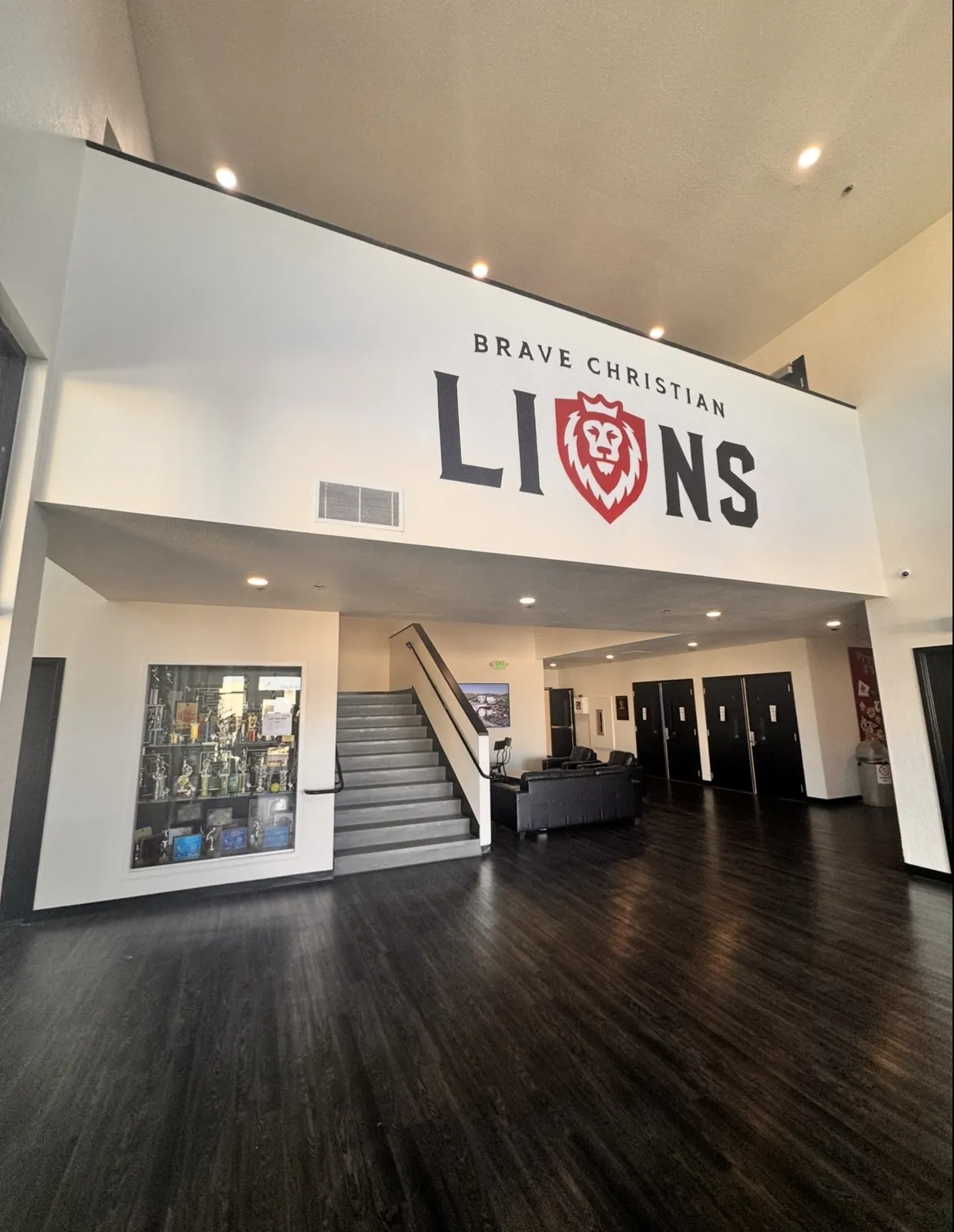 High school lobby view of the Brave Christian LIONS mural and staircase